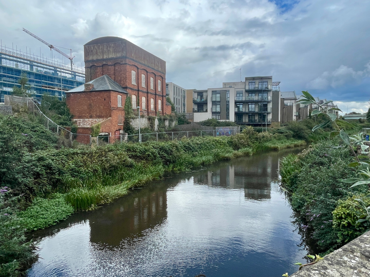 The River Tone in Taunton, with a red brick building and cloudy sky